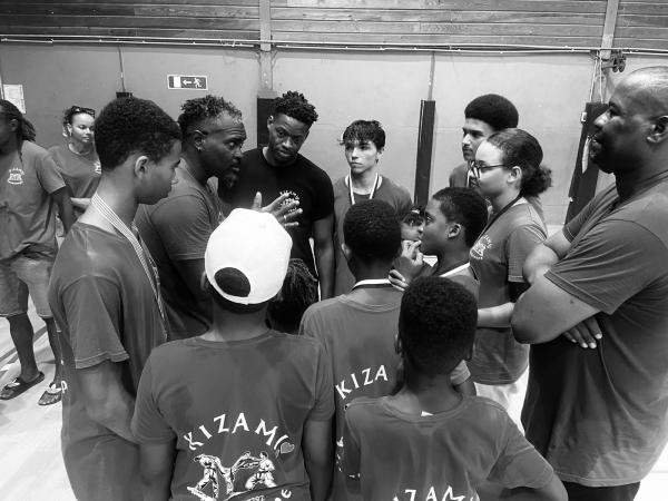 Le groupe rassemblé en cercle avant un entraînement, photographie en noir et blanc